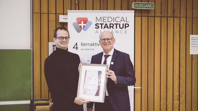 Photo of Stefan Tenzer getting a plaque for the Innovation price by Ralf Kiesslich