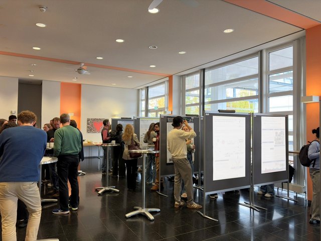 Poster session with groups of attendees viewing and discussing research posters.