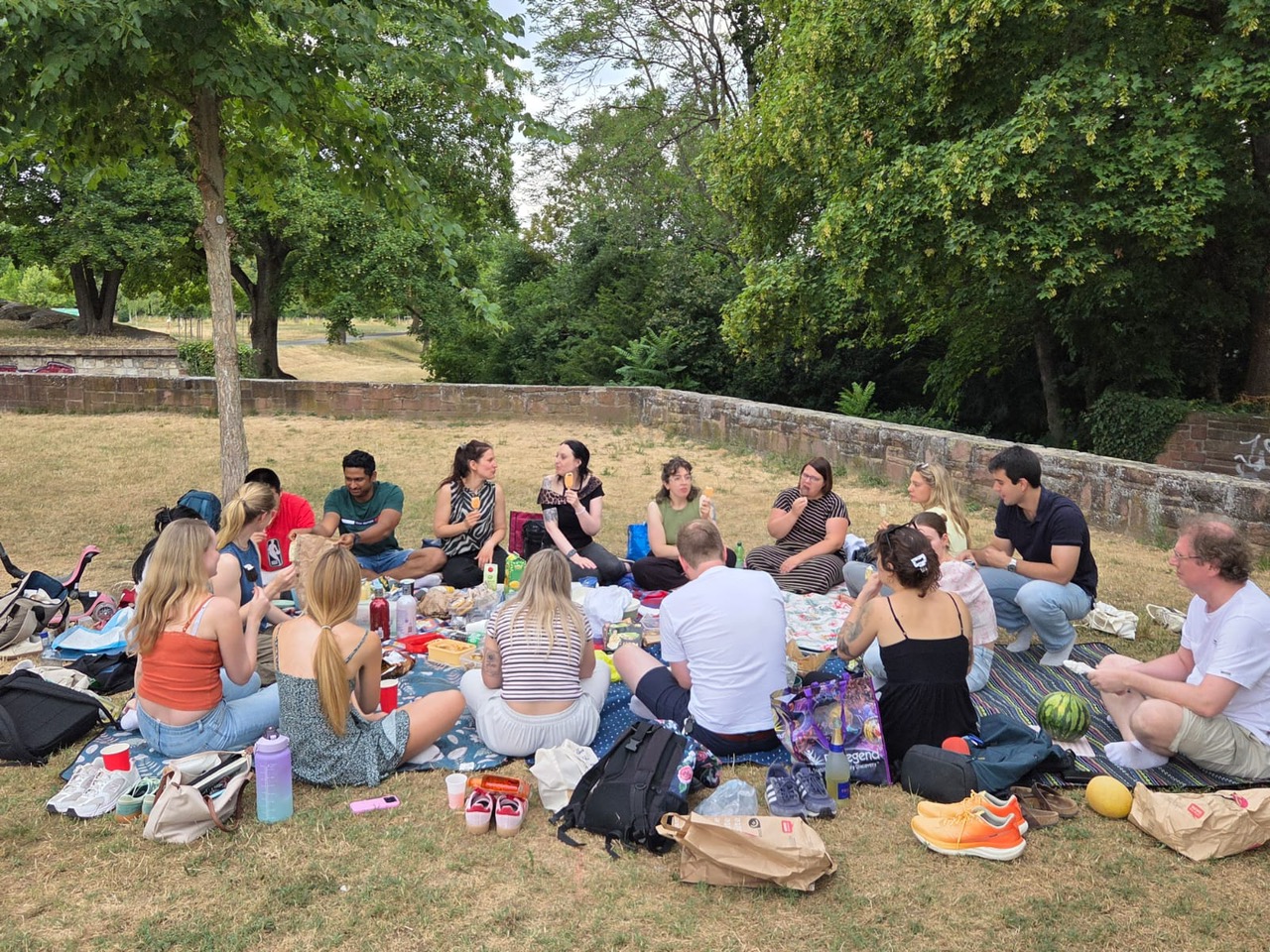 People sitting together on picnic blankets, sharing food and conversation